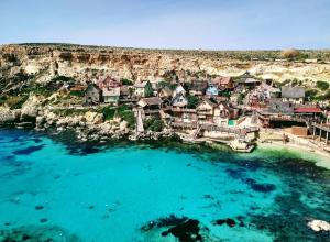 an aerial view of a village on the shore of a body of water at Peaceful 2 bed, 2 bath flat & breathtaking views in Mellieħa
