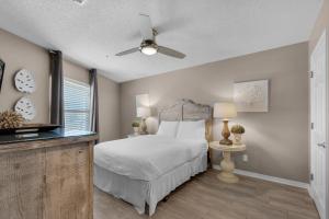 a bedroom with a bed and a flat screen tv at Emerald Gulf Escape at Miramar Beach in Destin +15 photos