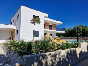a white house with a tree in front of it at Villa Atma in Murine