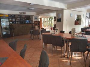 a restaurant with tables and chairs and a bar at Pensiunea Valea Negrasului in Trăisteni