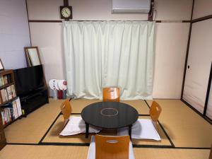 a room with a table and chairs and a television at Kyoto151 in Kyoto