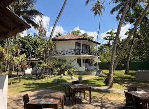 a house with tables and chairs and palm trees at Lido Dikwella in Dickwella
