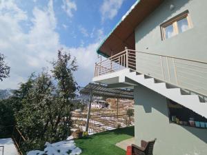 a house with a balcony with a view at The Northern Nook in Mukteshwar