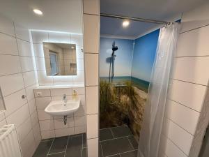 a bathroom with a sink and a shower with a picture of a beach at Ferienhaus Pank in Heringsdorf +42 photos