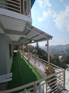 a balcony of a house with awnings on it at The Northern Nook in Mukteshwar +15 photos