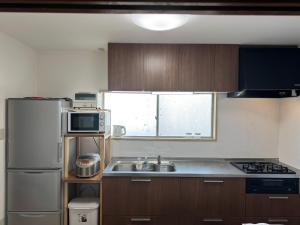 a kitchen with a sink and a refrigerator at Kyoto151 in Kyoto