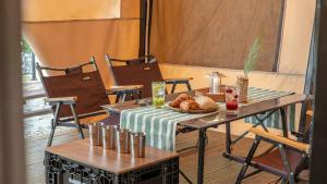 a table with a plate of bread on it on a balcony at Mungyeong The Most Glamping in Mungyeong