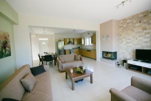 a living room with couches and a table and a fireplace at Evi's Sea View Villa in Gennadi