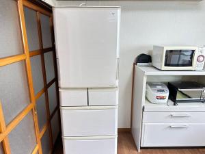 a white refrigerator in a room with a microwave at さくらもり in Nagano +9 photos