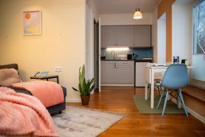 a living room with a couch and a table and a kitchen at Quiet Nature Studio in Lahemaa, Garden, Terrace and pet friendly in Kolga