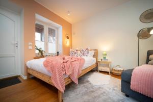 a bedroom with a bed with a pink blanket on it at Quiet Nature Studio in Lahemaa, Garden, Terrace and pet friendly in Kolga