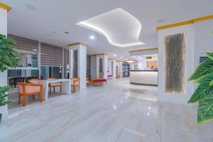 an open living room with a table and chairs at Grand Barhan Hotel Alanya in Alanya