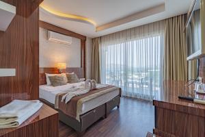 a hotel room with two beds and a large window at Grand Barhan Hotel Alanya in Alanya +20 photos