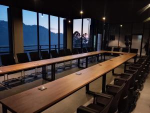 a row of tables and chairs in a room with windows at Zesora Nathia Gali in Nathia Gali