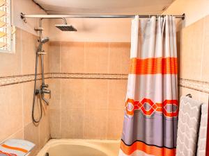 a shower with a colorful shower curtain in a bathroom at 1Dom Rep - Huge cozy 3 bedrooms - close to all transportation Jacobo Majluta - Residencial Paradise V Colina Arroyo 1 in Santo Domingo +199 photos