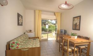 a living room with a table and a couch and a dining room at Residence Airone in Orbetello