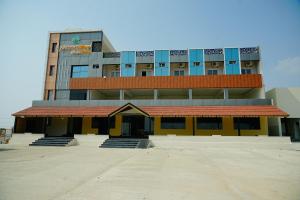 a large building with a yellow and blue building at AAryavarth suites 46 in Pālasmudram