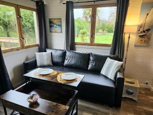 a living room with a couch and a table at Climatisation avec La Rouyonnaise in Tinténiac