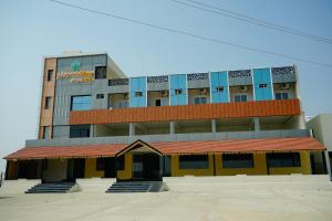 a tall building with a yellow and blue building at AAryavarth suites 46 in Pālasmudram