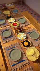 a wooden table with plates and utensils on it at Dar Imim Surf House in Taghazout