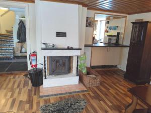 a living room with a fireplace and a kitchen at Charming red cottage in Vaderstad SE10024 in Väderstad