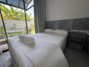 two beds in a hotel room with a window at Ranbin Retreat in Manadhoo