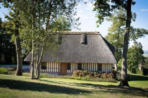 a house with a thatched roof with trees at Holiday home Le clos du phare in Saint-Samson-de-la-Roque