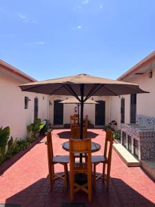 a table and chairs under an umbrella on a patio at Amora Homestay and Safaris in Karatu