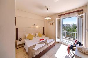 a bedroom with a bed and a large window at Francoise Hotel in Galissas