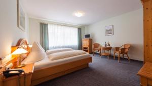 una camera d'albergo con letto, tavolo e sedie di Zum Fässle a Hagnau
