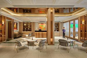 a man standing in a lobby with a table and chairs at La Siesta Premium Lakeside in Hanoi