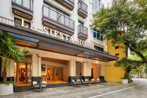 a facade of a hotel with chairs in front of it at La Siesta Premium Lakeside in Hanoi +123 photos