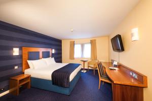 a hotel room with a bed and a desk at Leonardo Inn Aberdeen Airport in Dyce