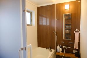 a bathroom with a tub and a shower with a sink at スローライフ喜界 in Onozu +39 photos