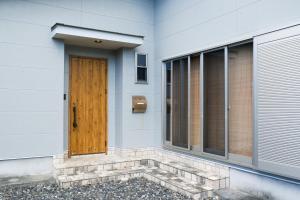 a wooden door on the side of a house at スローライフ喜界 in Onozu