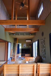 a living room with a couch and a loft at スローライフ喜界 in Onozu