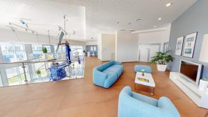 a living room with blue chairs and a tv at Aircraft Hotel & Events in Neuhausen ob Eck