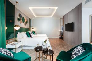 a hotel room with a bed and two green chairs at La Seine Boutique Hotel in Vientiane