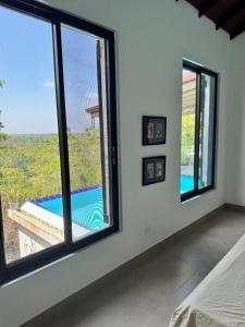 a bedroom with windows and a view of a pool at The Ellen Horizon in Ganegama South +17 photos