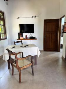 a room with a table and a chair and a television at The Ellen Horizon in Ganegama South