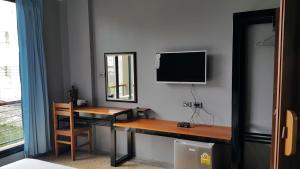 a room with a desk and a television on a wall at ChomTrang in Trang