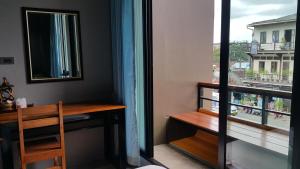 Habitación con escritorio, espejo y ventana. en ChomTrang, en Trang