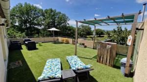 a patio with two lounge chairs and a pergola at Les 3 Chênes in Puechredon