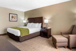 a hotel room with a bed and a chair at Comfort Inn Pearl-Jackson in Pearl
