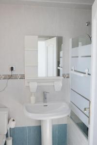 a white bathroom with a sink and a mirror at Brisa Chilches nº 5 in Málaga +10 photos