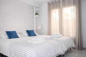 a bedroom with a large bed with towels on it at Brisa Chilches nº 5 in Málaga
