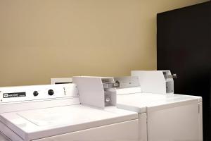 a laundry room with white washing machines and a black door at Rodeway Inn & Suites Chandler - Phoenix South I-10 in Chandler +2 photos
