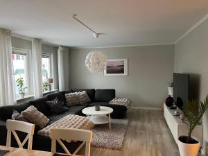 a living room with a black couch and a table at Rymligt radhus in Borlänge