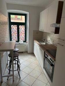 a kitchen with a sink and a table and a window at RosenSuite SGH in Sangerhausen