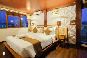 a bedroom with a bed in a room with windows at The Phalosaa Villa unit Family in Ngaglik +9 photos